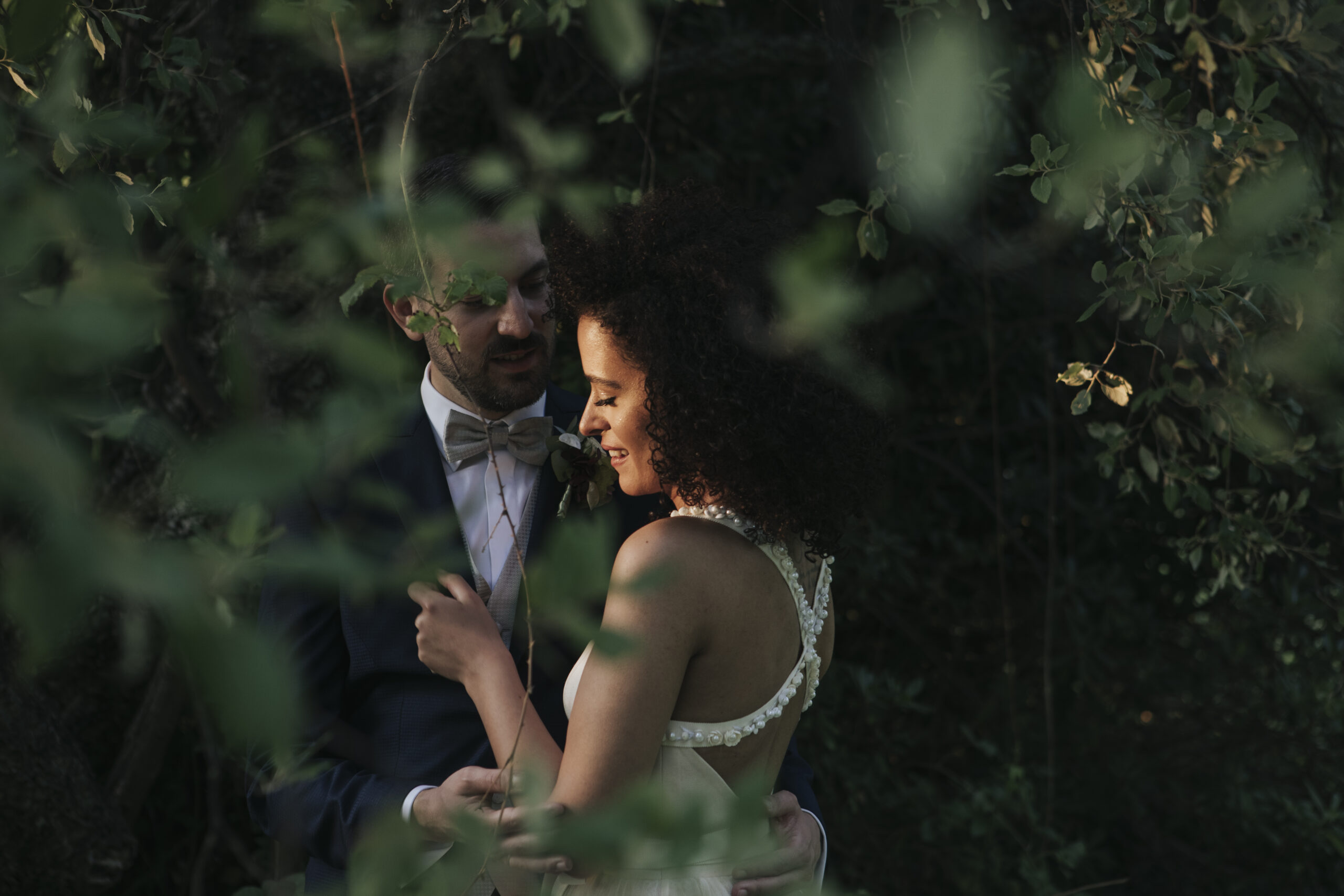 Una coppia di stranieri si scambia uno sguardo di amore nel giardino del ristorante Le Case di Macerata durante il loro matrimonio.